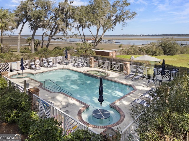 view of pool featuring a community hot tub, a patio, a water view, and fence