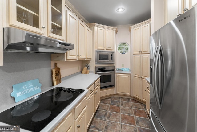 kitchen with cream cabinetry, stainless steel appliances, light countertops, glass insert cabinets, and under cabinet range hood