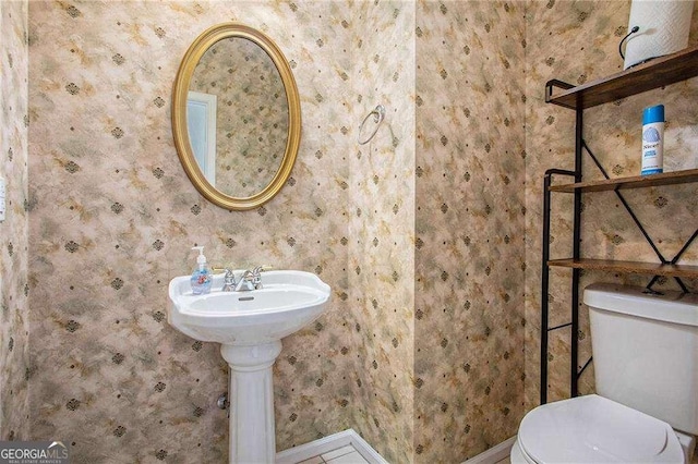 bathroom featuring toilet and wallpapered walls