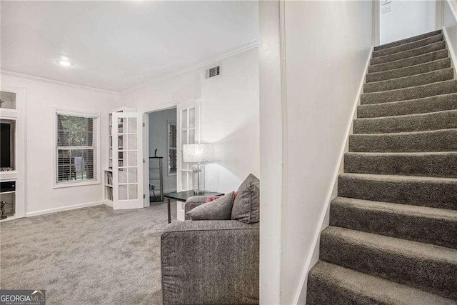 stairs featuring carpet floors, visible vents, ornamental molding, and baseboards