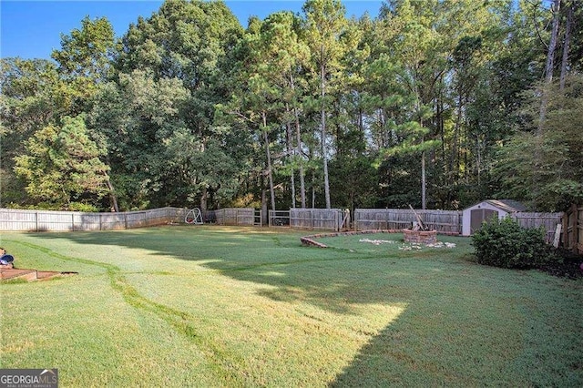 view of yard featuring a fenced backyard, an outdoor structure, and a storage unit