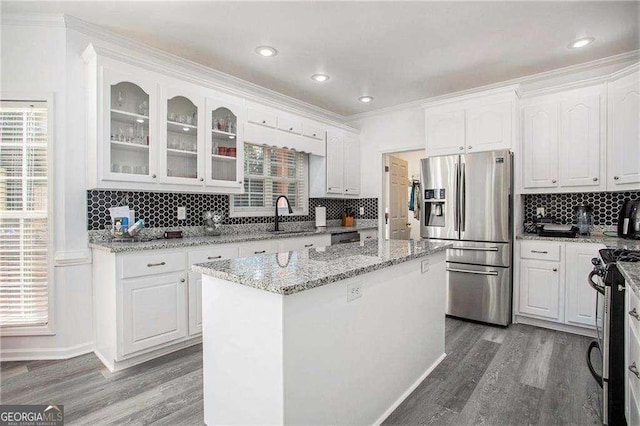 kitchen featuring appliances with stainless steel finishes, wood finished floors, and white cabinetry