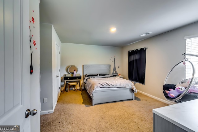 bedroom featuring visible vents, light carpet, and baseboards