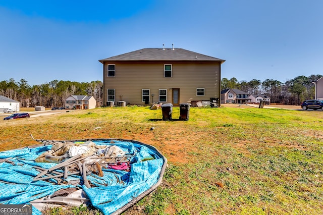 back of property featuring central air condition unit and a lawn