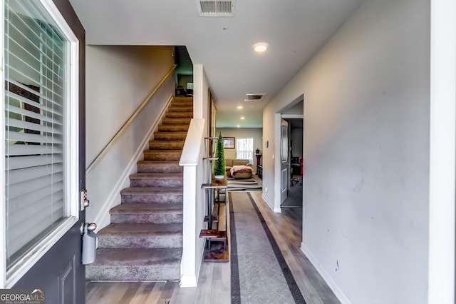 staircase featuring recessed lighting, visible vents, and wood finished floors