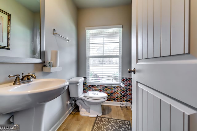 bathroom with a sink, toilet, baseboards, and wood finished floors