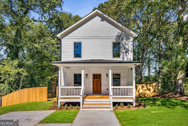 view of front of home featuring a porch, a front lawn, and fence