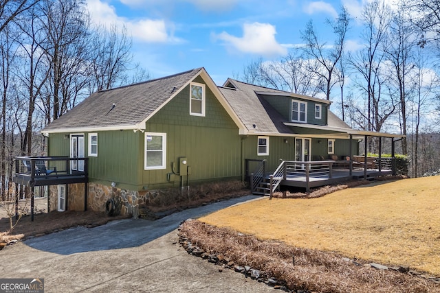 exterior space featuring a front lawn and a wooden deck