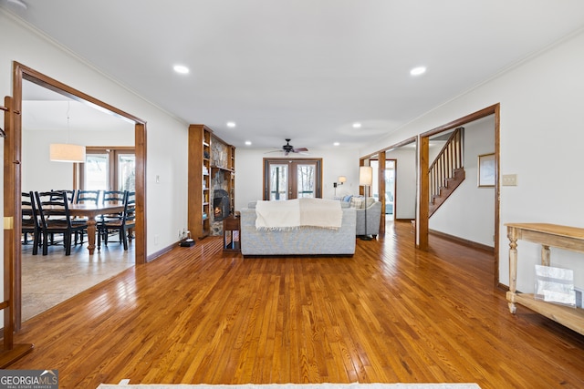 unfurnished living room featuring light wood-type flooring, a healthy amount of sunlight, crown molding, and french doors