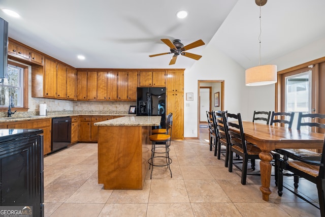 kitchen featuring black appliances, a kitchen island, decorative backsplash, and brown cabinets