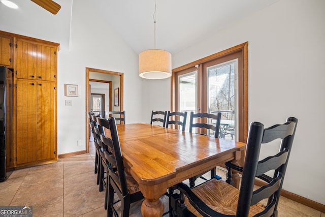 dining space featuring baseboards and vaulted ceiling