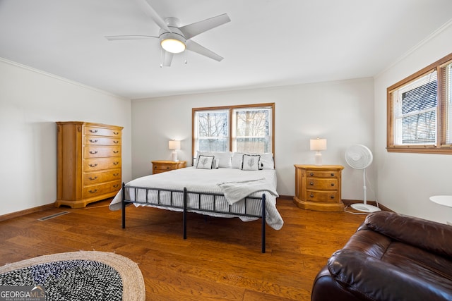 bedroom featuring multiple windows, wood finished floors, and crown molding