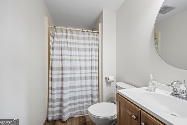 full bathroom with visible vents, toilet, a shower with curtain, wood finished floors, and vanity