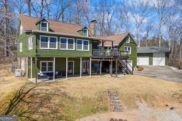 exterior space with central AC unit, a chimney, stairs, a wooden deck, and an outdoor structure