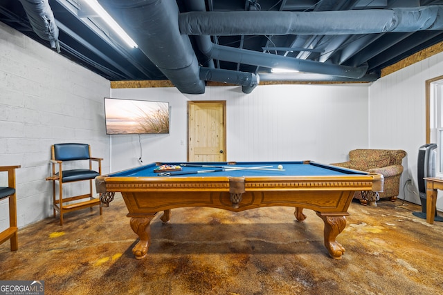 recreation room with concrete block wall, billiards, and concrete flooring