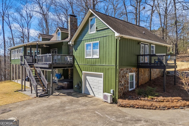 exterior space with a ceiling fan, concrete driveway, a chimney, stairs, and ac unit