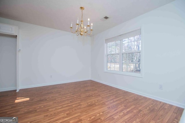 empty room with visible vents, baseboards, and wood finished floors