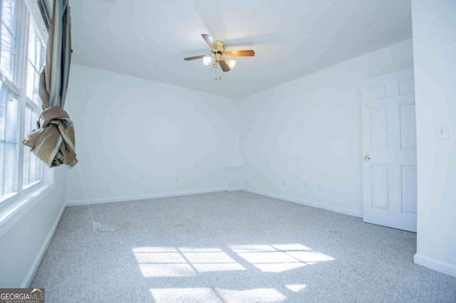 unfurnished room featuring carpet floors, a ceiling fan, and a wealth of natural light