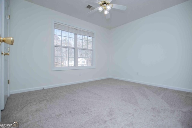 empty room with carpet, visible vents, baseboards, and a ceiling fan