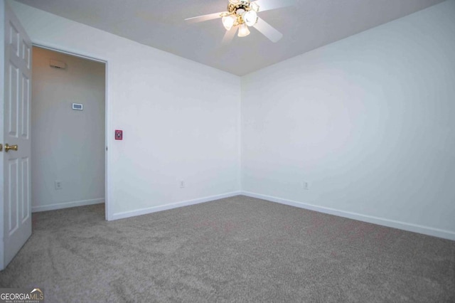 carpeted empty room featuring ceiling fan and baseboards