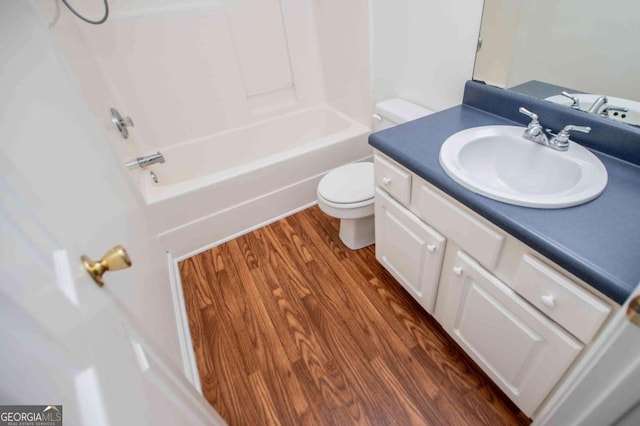 bathroom with toilet, bathing tub / shower combination, wood finished floors, and vanity