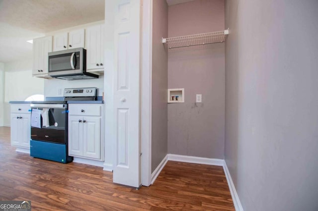 kitchen featuring baseboards, appliances with stainless steel finishes, dark wood finished floors, and white cabinets