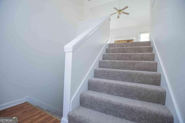 stairs featuring ceiling fan, baseboards, and wood finished floors