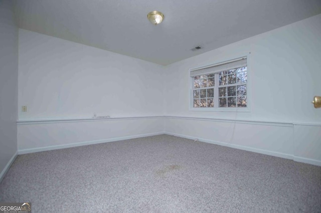 spare room with carpet, visible vents, and baseboards