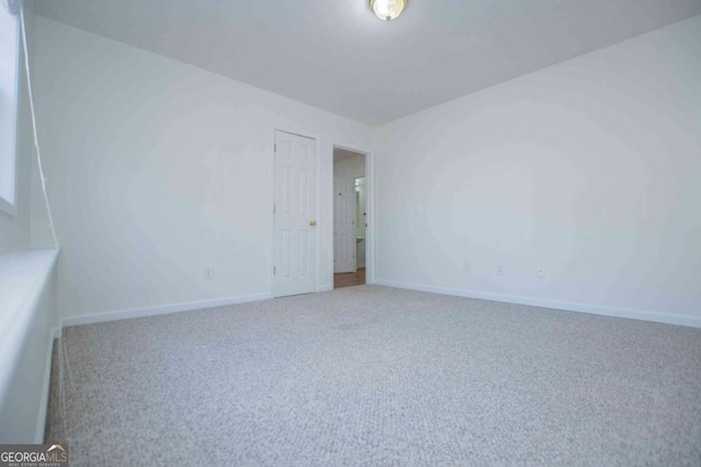 carpeted spare room featuring baseboards