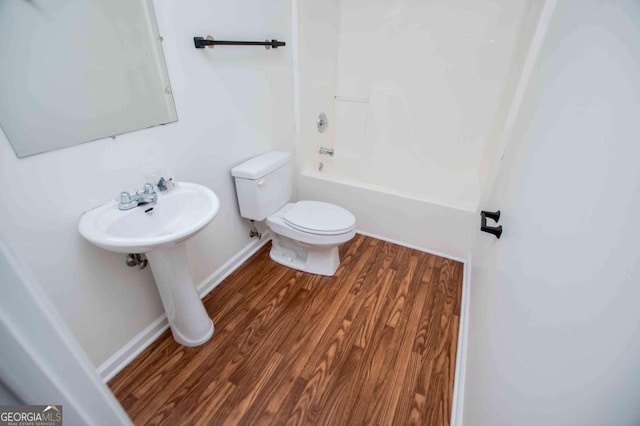 full bathroom featuring baseboards, toilet, shower / tub combination, wood finished floors, and a sink