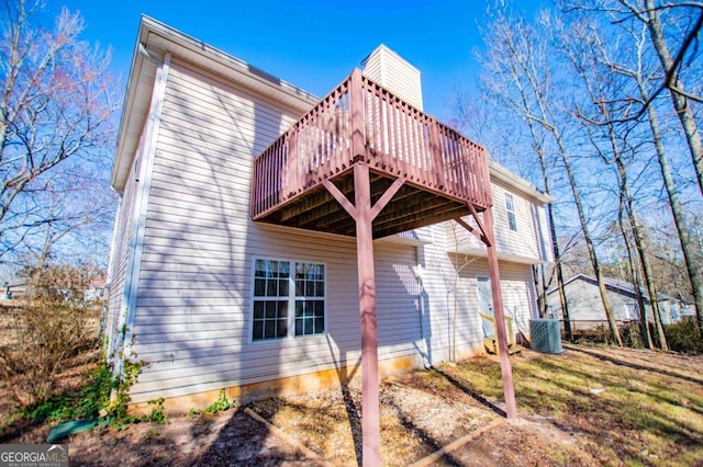 view of side of home with central AC unit and a wooden deck