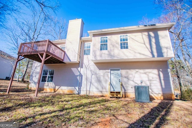 back of house featuring a deck, cooling unit, a chimney, and entry steps