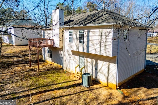 view of side of home featuring a chimney and cooling unit