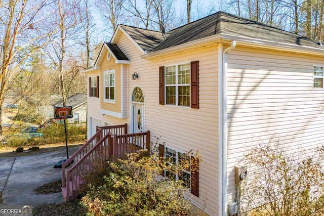 view of side of home featuring driveway and an attached garage