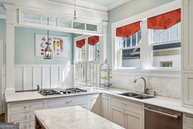 kitchen featuring tasteful backsplash, ornamental molding, stainless steel appliances, white cabinetry, and a sink