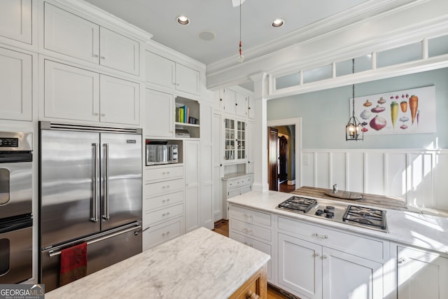 kitchen with recessed lighting, stainless steel appliances, white cabinets, ornamental molding, and pendant lighting