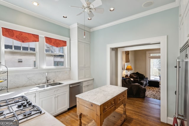 kitchen featuring appliances with stainless steel finishes, white cabinetry, ornamental molding, and decorative backsplash