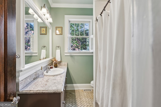 bathroom with toilet, ornamental molding, vanity, tile patterned flooring, and baseboards