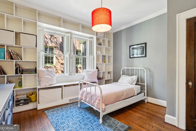 bedroom featuring ornamental molding, wood finished floors, and baseboards