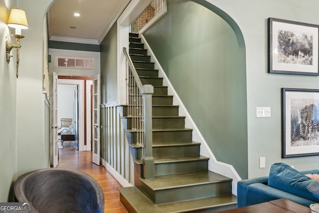 stairway featuring arched walkways, ornamental molding, wood finished floors, and recessed lighting