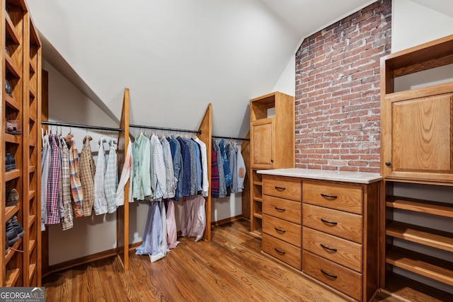 spacious closet featuring vaulted ceiling and wood finished floors