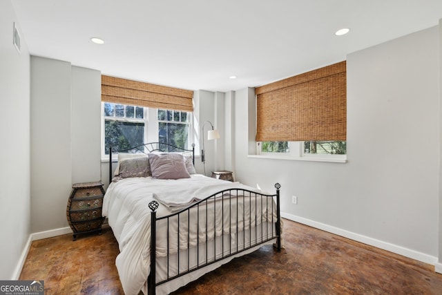 bedroom featuring concrete floors, multiple windows, baseboards, and recessed lighting