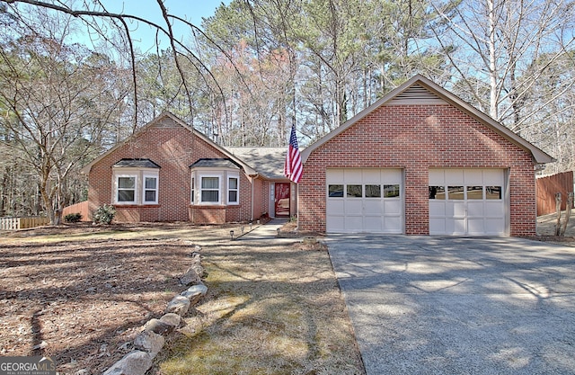 ranch-style house featuring brick siding, driveway, an attached garage, and fence