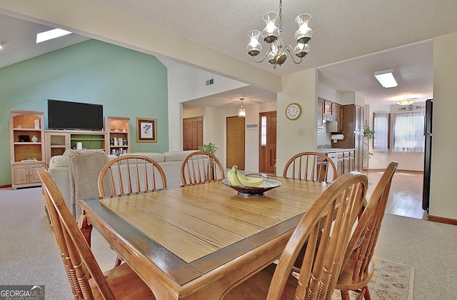 dining area featuring a notable chandelier, lofted ceiling, visible vents, carpet flooring, and a textured ceiling