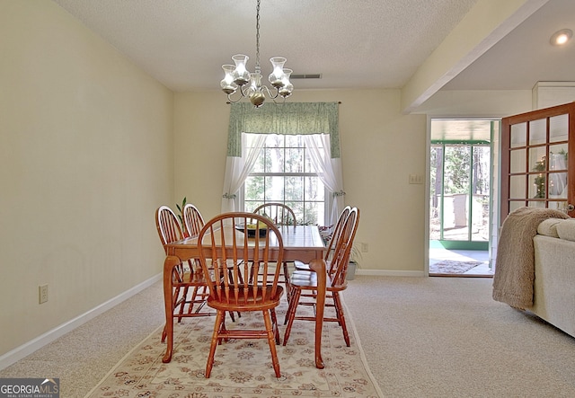 dining room featuring a healthy amount of sunlight, light carpet, and an inviting chandelier