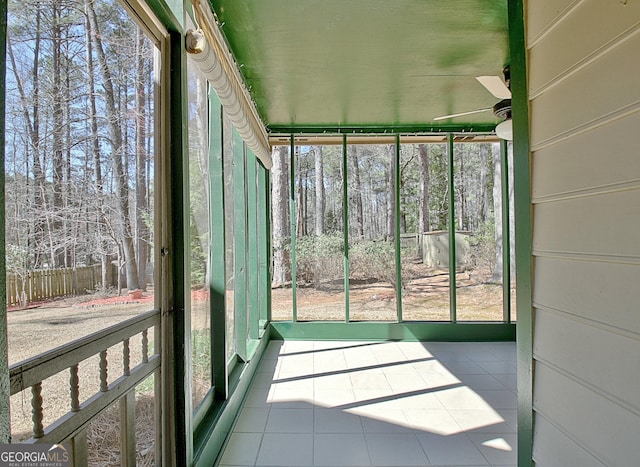 unfurnished sunroom with ceiling fan and plenty of natural light