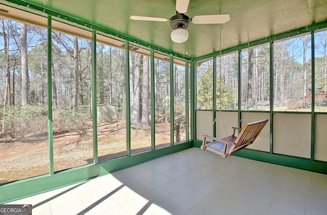 unfurnished sunroom with ceiling fan