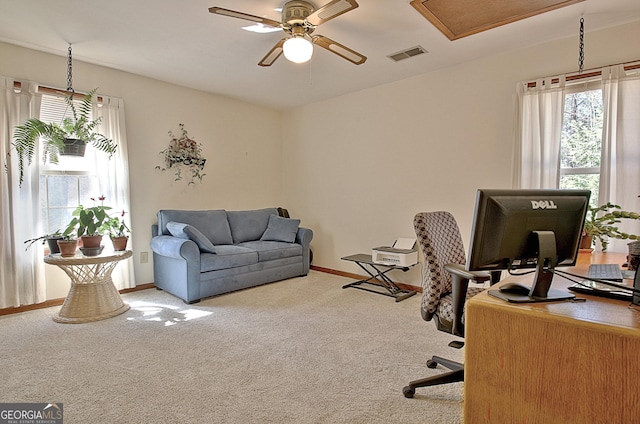 carpeted office with baseboards, visible vents, and a ceiling fan