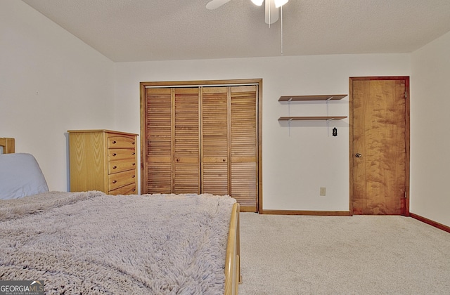 unfurnished bedroom featuring carpet floors, a closet, a ceiling fan, a textured ceiling, and baseboards