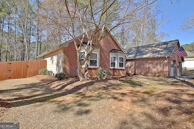 view of front facade with a garage, a gate, brick siding, and fence